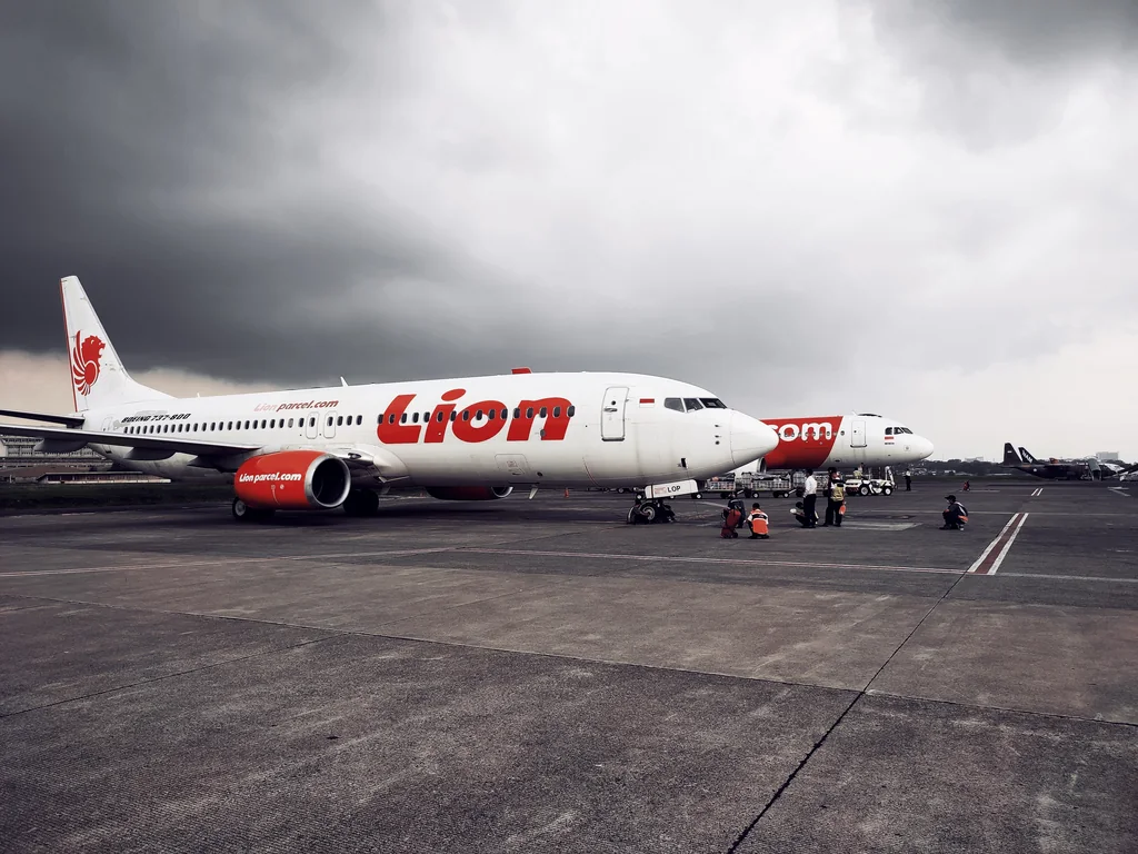 Pesawat Boeing 737-800 Lion Air terparkir di apron Bandara Husein Sastranegara, Bandung, dengan kru darat di sampingnya, 2021