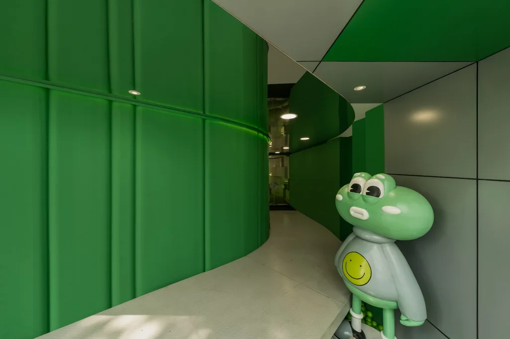 A frog figure standing in a curved green corridor at Noisy Matcha