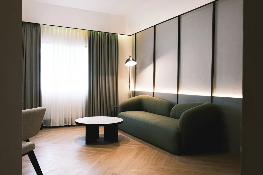 Area duduk suite dengan sofa hijau dan meja bundar