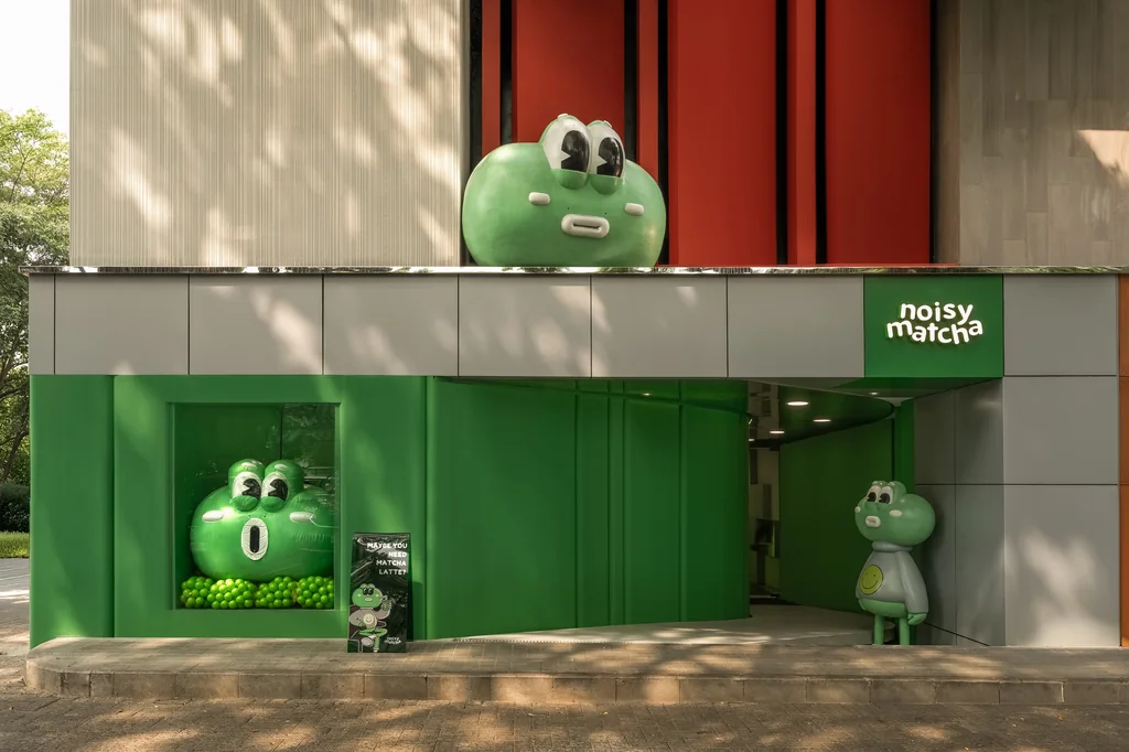Muka bangunan Noisy Matcha 2.0 berwarna hijau dan abu-abu, dengan patung kodok besar di atas pintu masuk dan yang lebih kecil di samping pintu